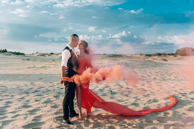 Coppie adorabili eleganti che posano sulla spiaggia