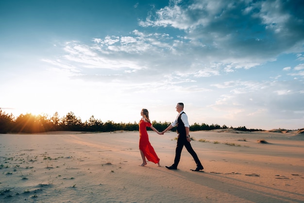 Coppie adorabili eleganti che posano sulla spiaggia