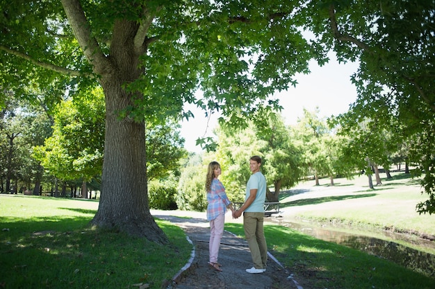 Coppie affettuose sveglie che camminano congiuntamente nel parco