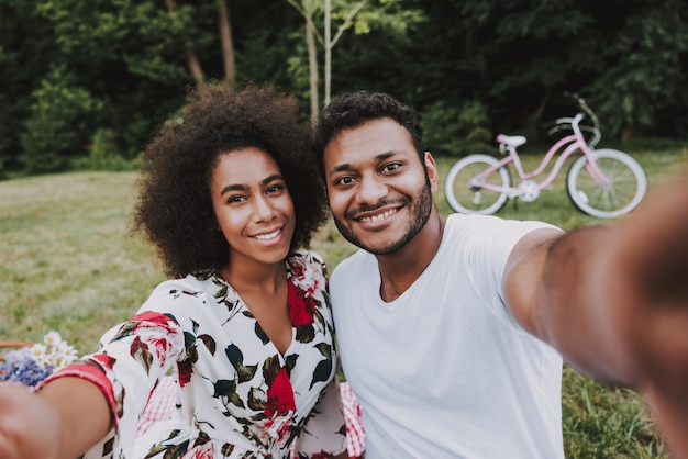 Coppie afroamericane che fanno selfie su un picnic