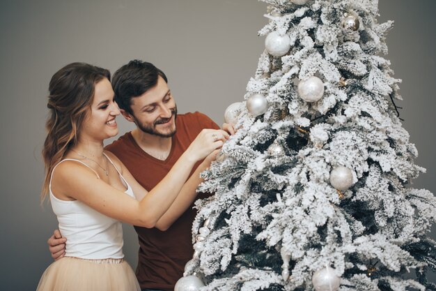 Coppie amorose che decorano l'albero di Natale. Famiglia felice