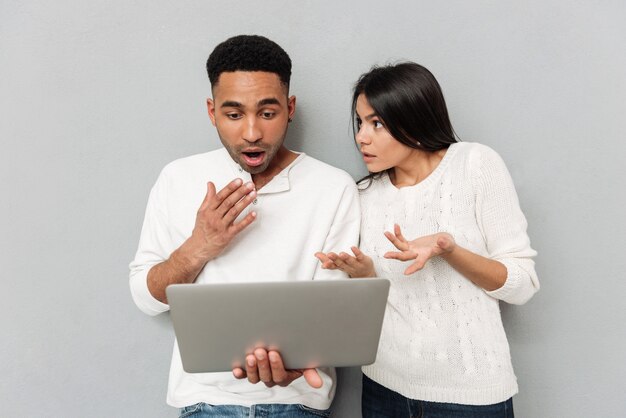 Coppie amorose colpite che chiacchierano dal computer portatile