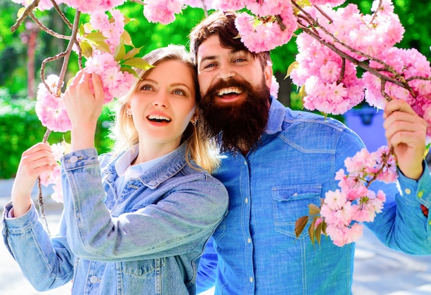 Coppie amorose della primavera nel giardino fiorito. Famiglia felice in albero di fiori di sakura.