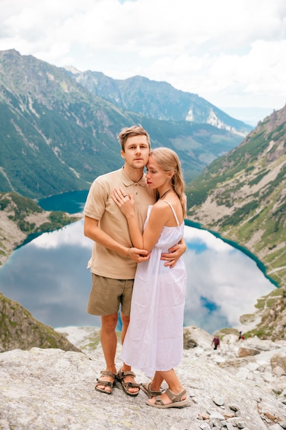 Coppie amorose felici che stanno insieme alla pietra nell'alto parco nazionale di Tatra in Polonia con un paesaggio pittoresco su fondo.