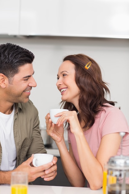 Coppie amorose felici con la tazza di caffè nella cucina a casa