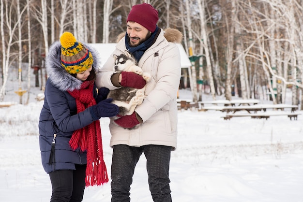 Coppie asiatiche che giocano con Husky Puppy