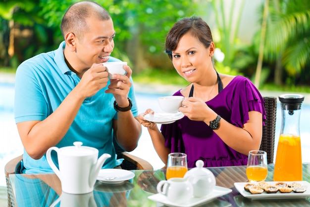 Coppie asiatiche che mangiano caffè sul portico domestico