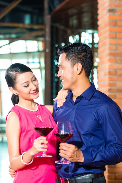 Coppie asiatiche con bicchiere di vino rosso