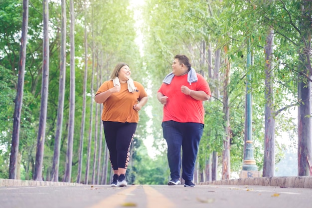 Coppie asiatiche grasse che chiacchierano allegramente mentre fanno jogging