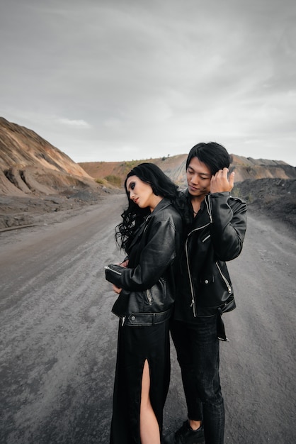 Coppie asiatiche nell'amore in vestiti di cuoio neri che camminano in natura. Amore, felicità