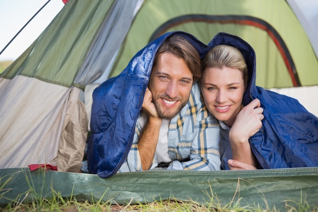 Coppie attraenti che si trovano nella loro tenda che sorride alla macchina fotografica