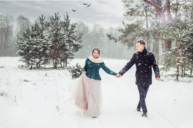 Coppie caucasiche di nozze nella fine di stagione invernale sul ritratto all'aperto. Amorevole tenero tenero coppia innamorata camminando insieme nella foresta appariscente