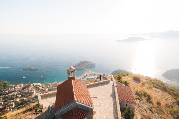 Coppie che abbracciano sul ponte di osservazione vicino all'antica chiesa di Sveti Savva in Montenegro. Filmati 4K di alta qualità