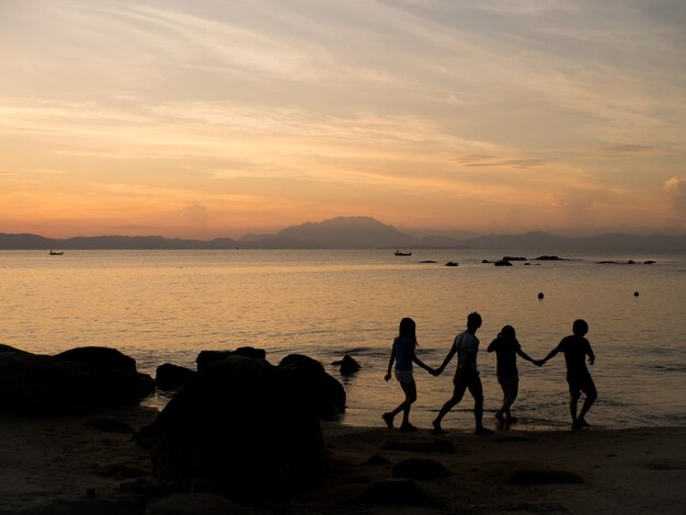 Coppie che camminano al tramonto sulla spiaggia