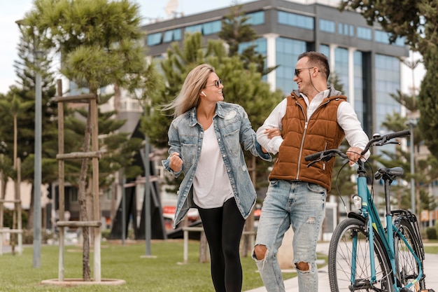 Coppie che camminano con una bicicletta accanto a loro