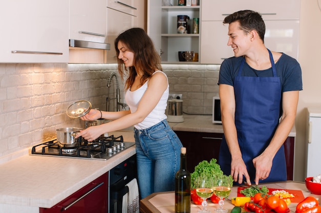 Coppie che cucinano insieme nella cucina a casa