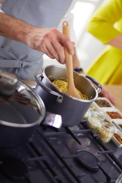 Coppie che cucinano insieme nella cucina a casa