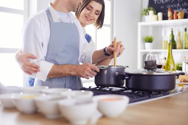 Coppie che cucinano insieme nella cucina a casa