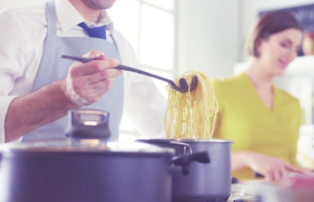 Coppie che cucinano insieme nella cucina a casa