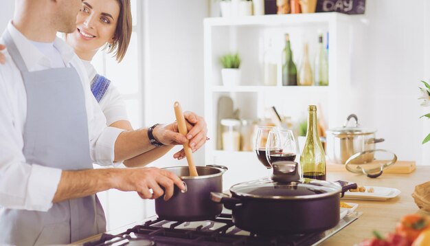 Coppie che cucinano insieme nella cucina a casa