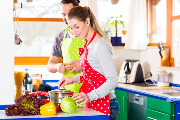 Coppie che cucinano nel cibo sano della cucina domestica