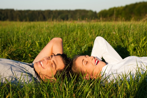 Coppie che dormono sul prato sotto il sole