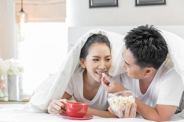 Coppie che fanno colazione sul letto