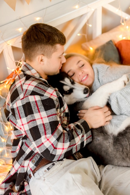 Coppie che giocano con il cane in camera da letto