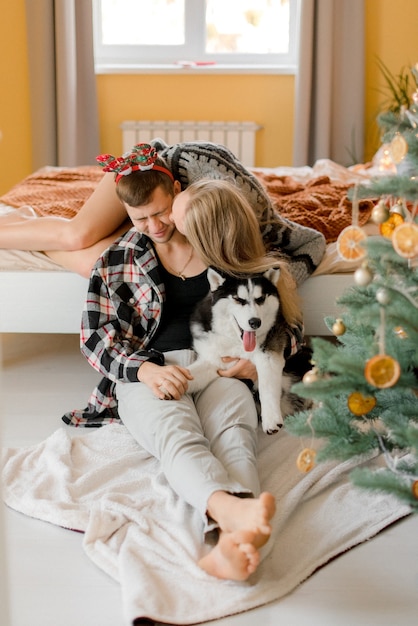 Coppie che giocano con il cane in camera da letto