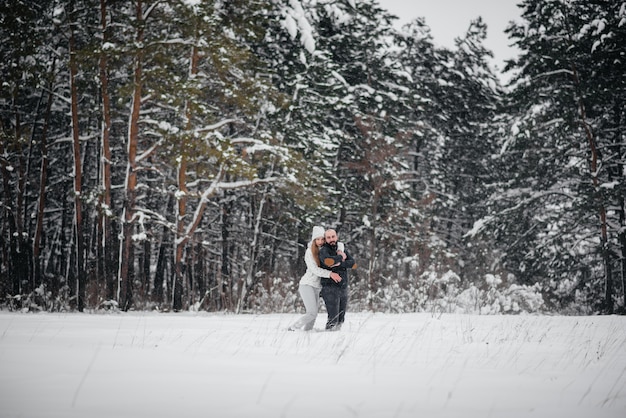 Coppie che giocano con la neve nella foresta