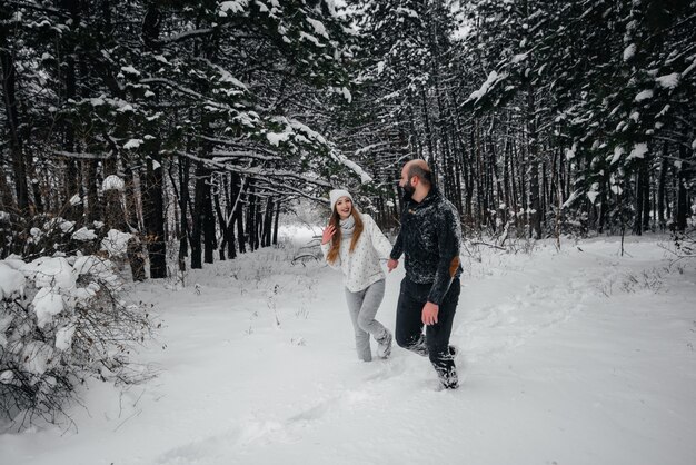 Coppie che giocano con la neve nella foresta