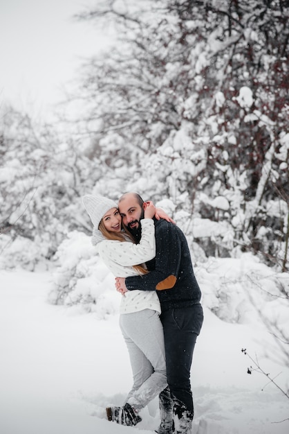 Coppie che giocano con la neve nella foresta