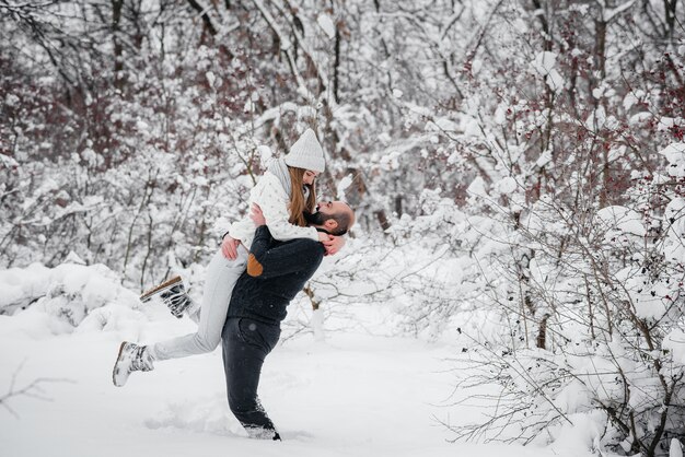 Coppie che giocano con la neve nella foresta