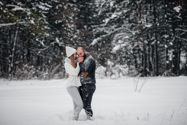 Coppie che giocano con la neve nella foresta