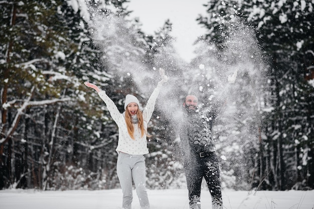 Coppie che giocano con la neve nella foresta