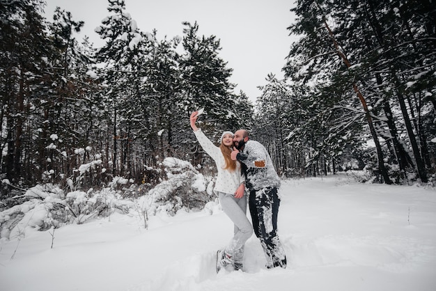 Coppie che giocano con la neve nella foresta.