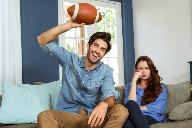 Coppie che guardano la partita di football americano sulla televisione