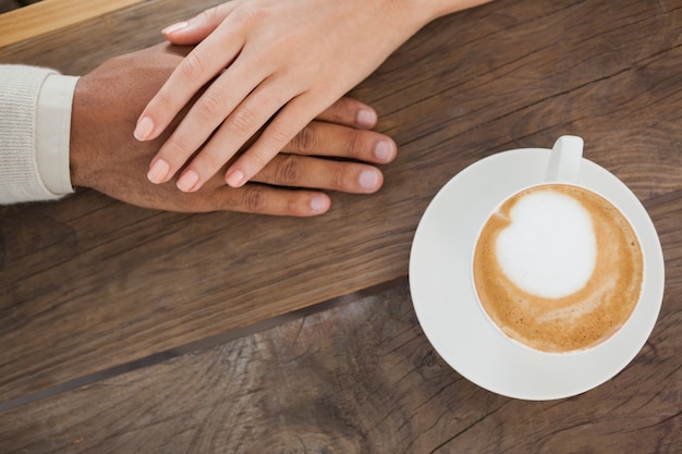 Coppie che si tengono per mano al lato del cappuccino