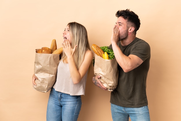 Coppie che tengono i sacchetti della spesa della drogheria