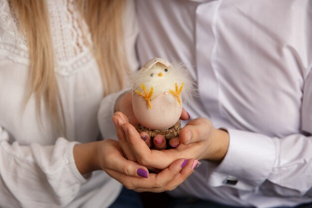 Coppie che tengono in mano uovo di Pasqua Con il pulcino