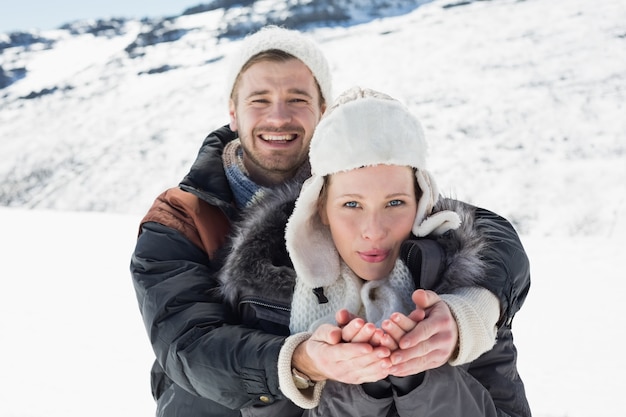 Coppie con le mani a coppa sul paesaggio nevicato