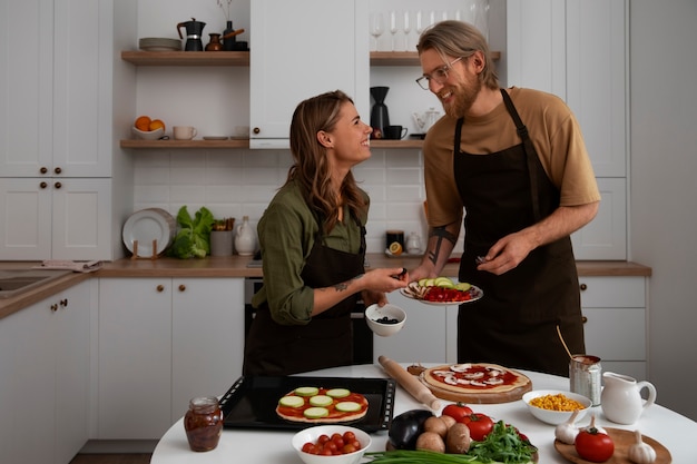 Coppie del colpo medio che cucinano insieme