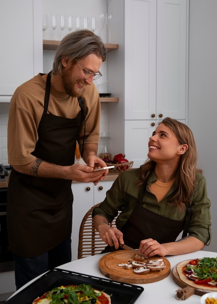 Coppie del colpo medio che cucinano insieme