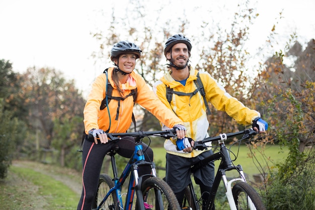 Coppie del motociclista che ciclano nella campagna