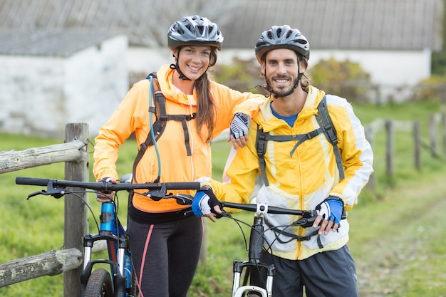 Coppie del motociclista con il mountain bike in campagna