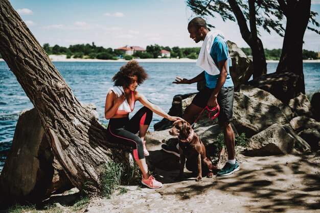 Coppie dell&#39;afroamericano sulla riva del fiume con Big Dog