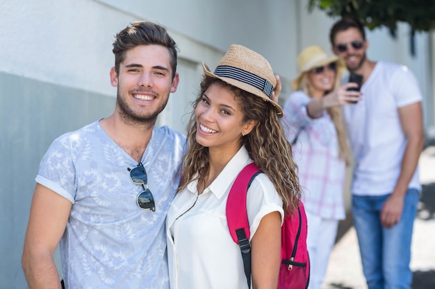 Coppie dell&#39;anca che sorridono alla macchina fotografica nella città