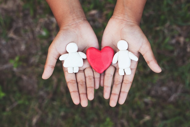 Coppie dell'argilla della plastilina con cuore sulla mano del bambino. Felice amante e concetto di San Valentino.