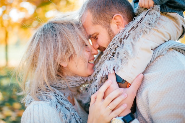 Coppie della famiglia all'aperto con il loro fare da baby-sitter sulle spalle dei padri.