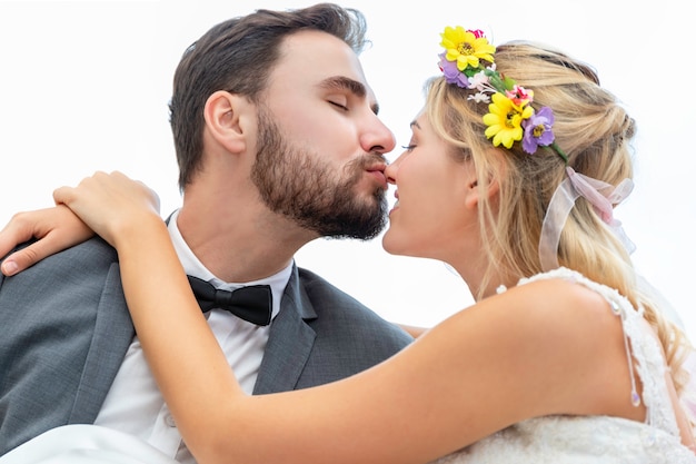 Coppie dello sposo e della sposa del bacio e dell'abbraccio caucasici nello studio di nozze.